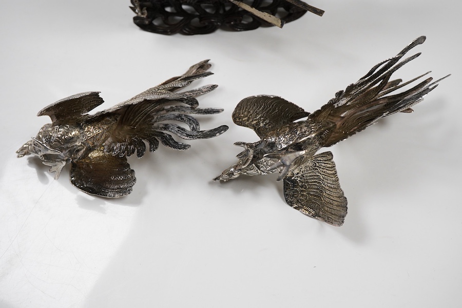 A pair of modern silver fighting cocks, import marks for Sheffield, Assay Office, Sheffield, 1977, height 68mm, together with a Chinese white metal miniature model of a ship, on a carved hardwood base, overall height 20.